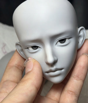 Close-up of a blank Muhan Bao 1/3 scale BJD doll head held in a hand
