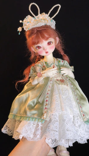 Muhan YOSD BJD doll in a green lace dress with an ornate pearl headpiece.