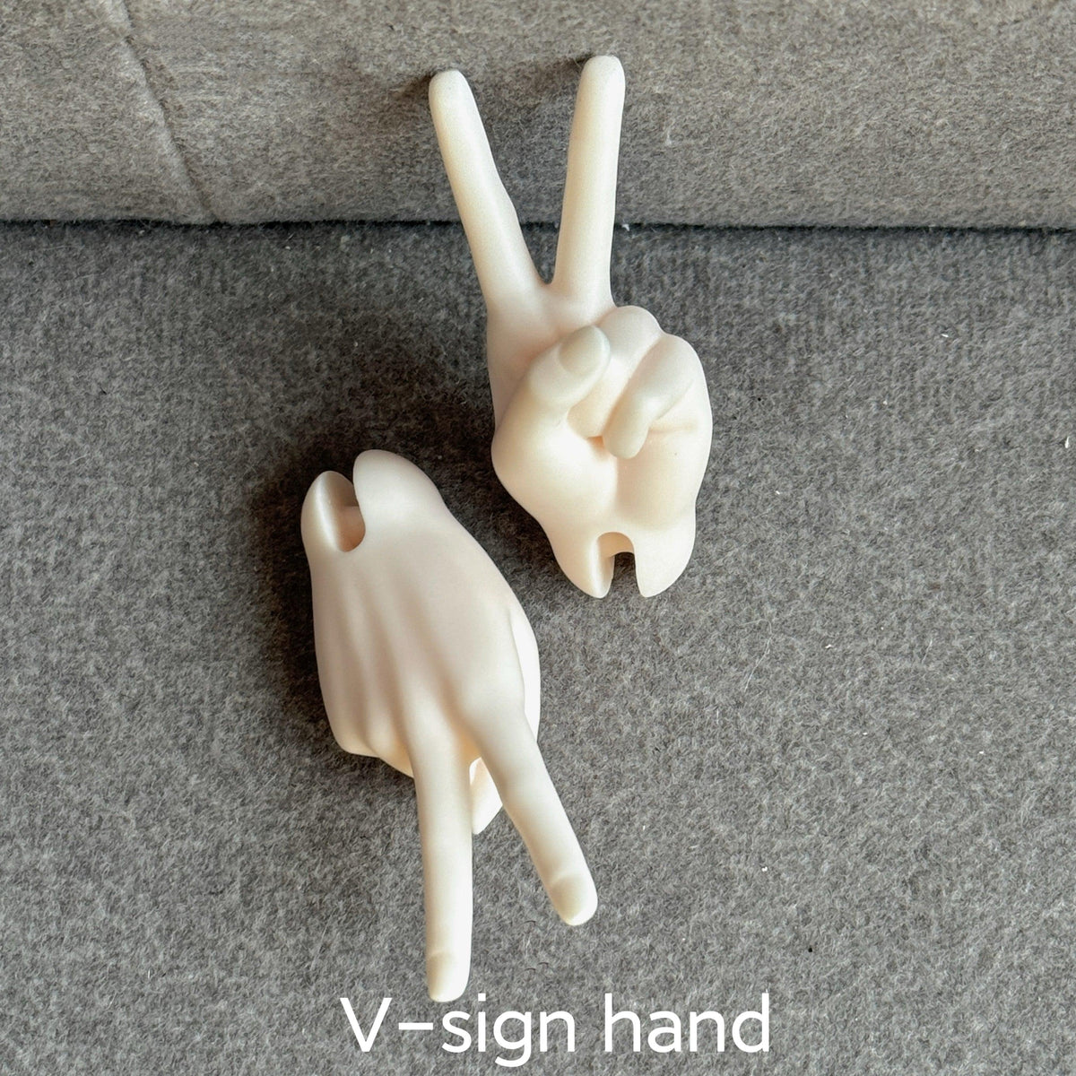 Two resin V-sign hand parts for MDollSchool 1/4 scale BJD dolls on a grey surface.