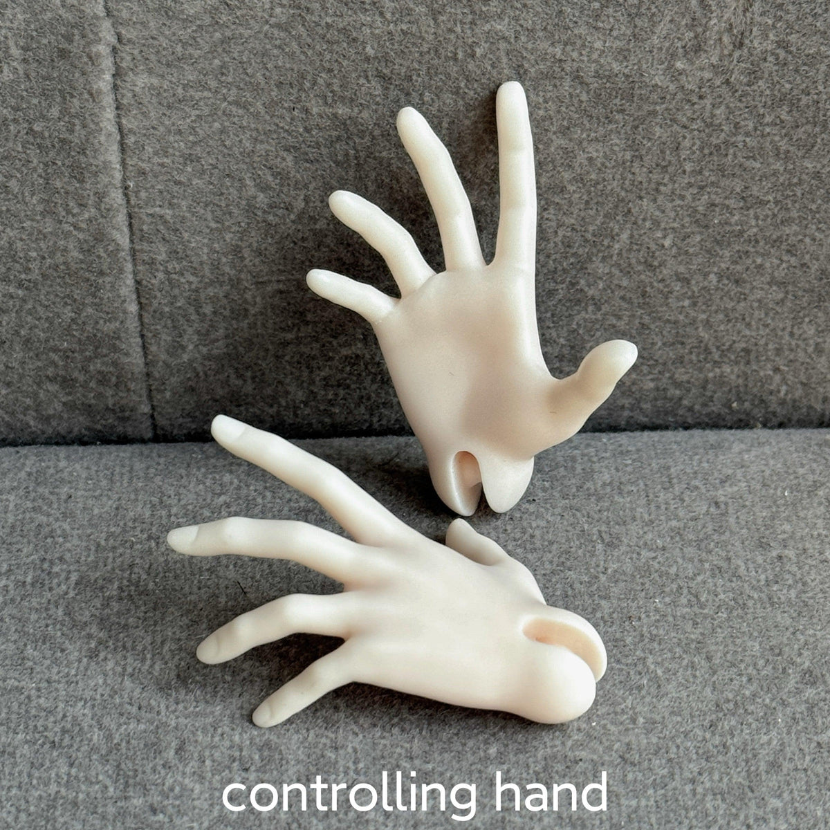 Two cream-colored resin controlling hands for MDollSchool BJD dolls on a grey fabric surface