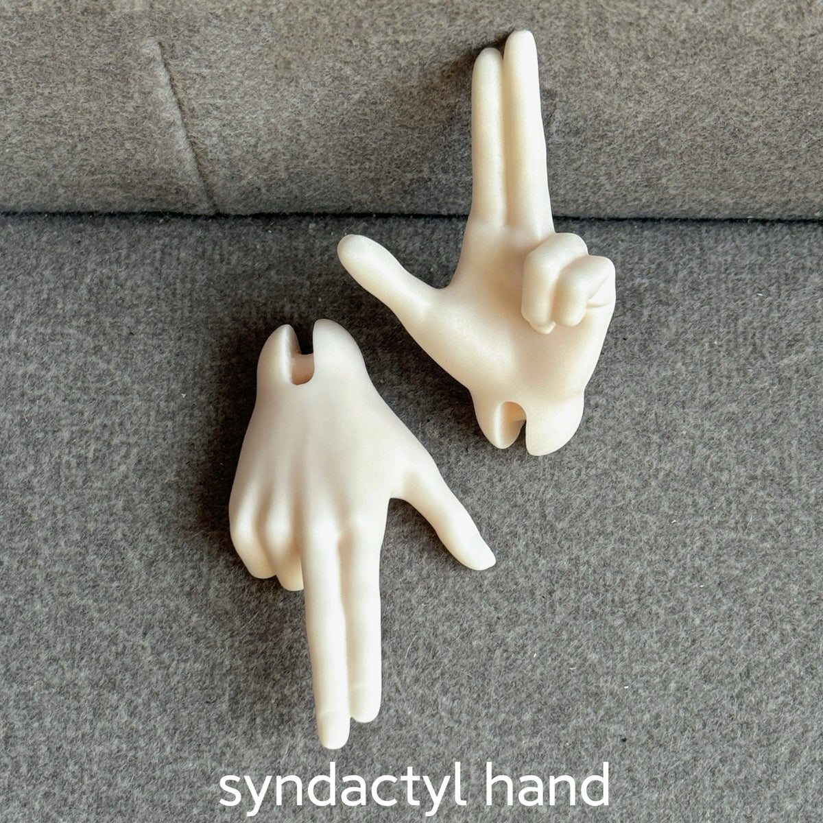 Two cream-colored resin syndactyl hands for MDollSchool 1/4 BJD dolls on a gray surface.