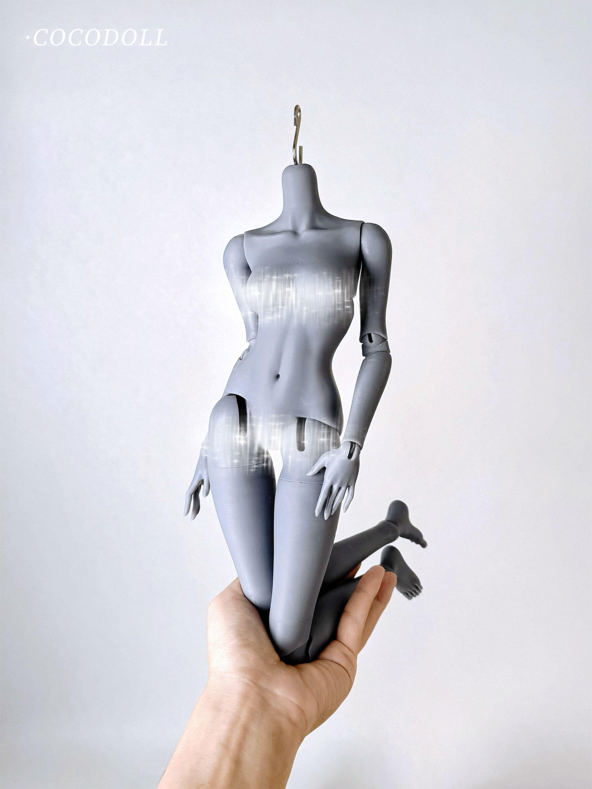 cocodollbjd White Choco 1/4 scale PVC doll body in a kneeling pose held by a hand