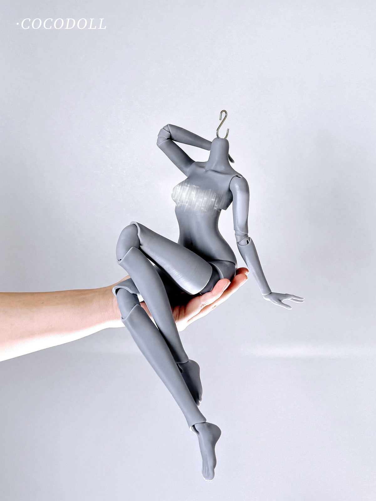 cocodollbjd White Choco 1/4 scale PVC doll body in grey, held in a hand for posing.